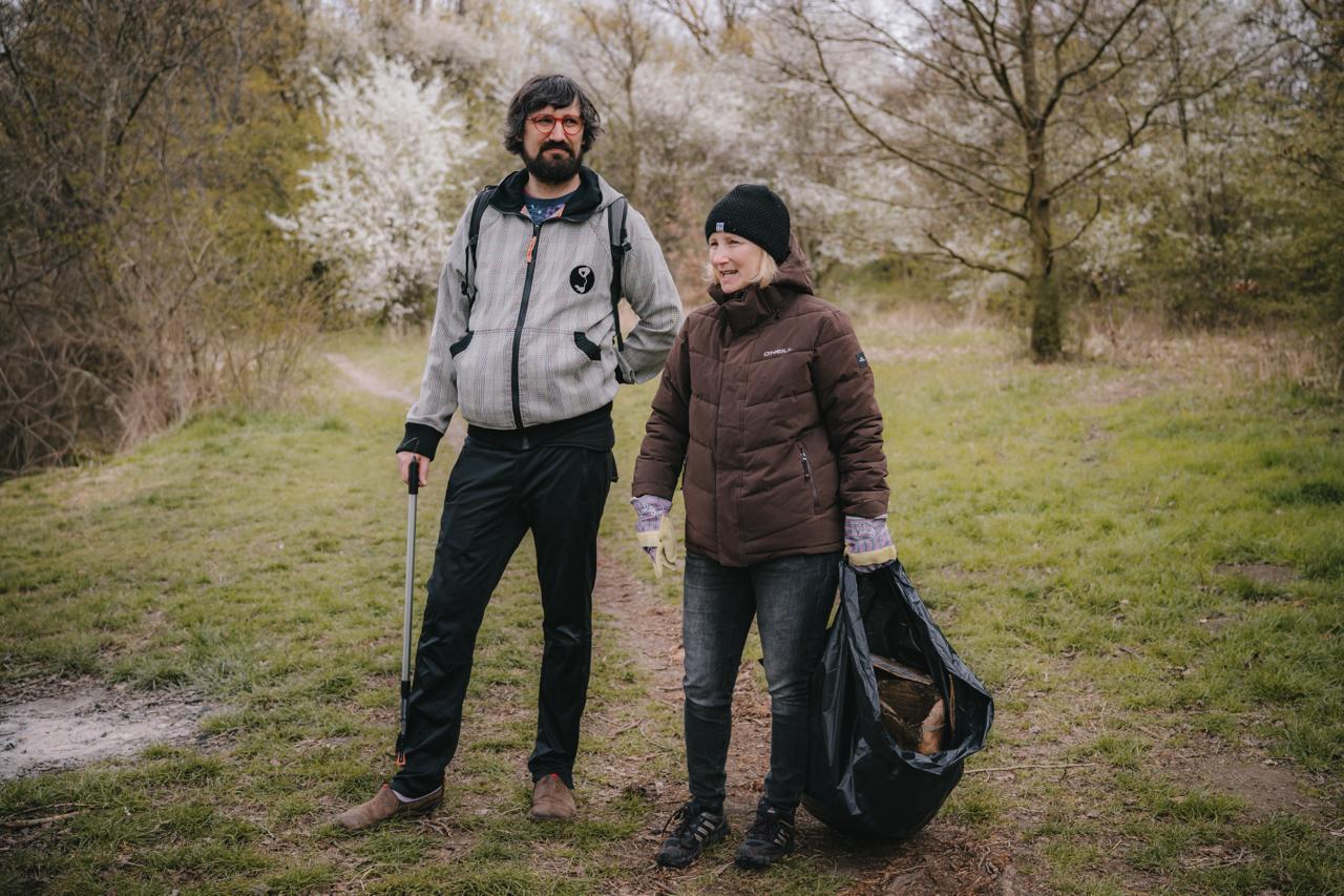 Dobrovolníci uklízí areál Džbán Praha 6 během komunitní akce