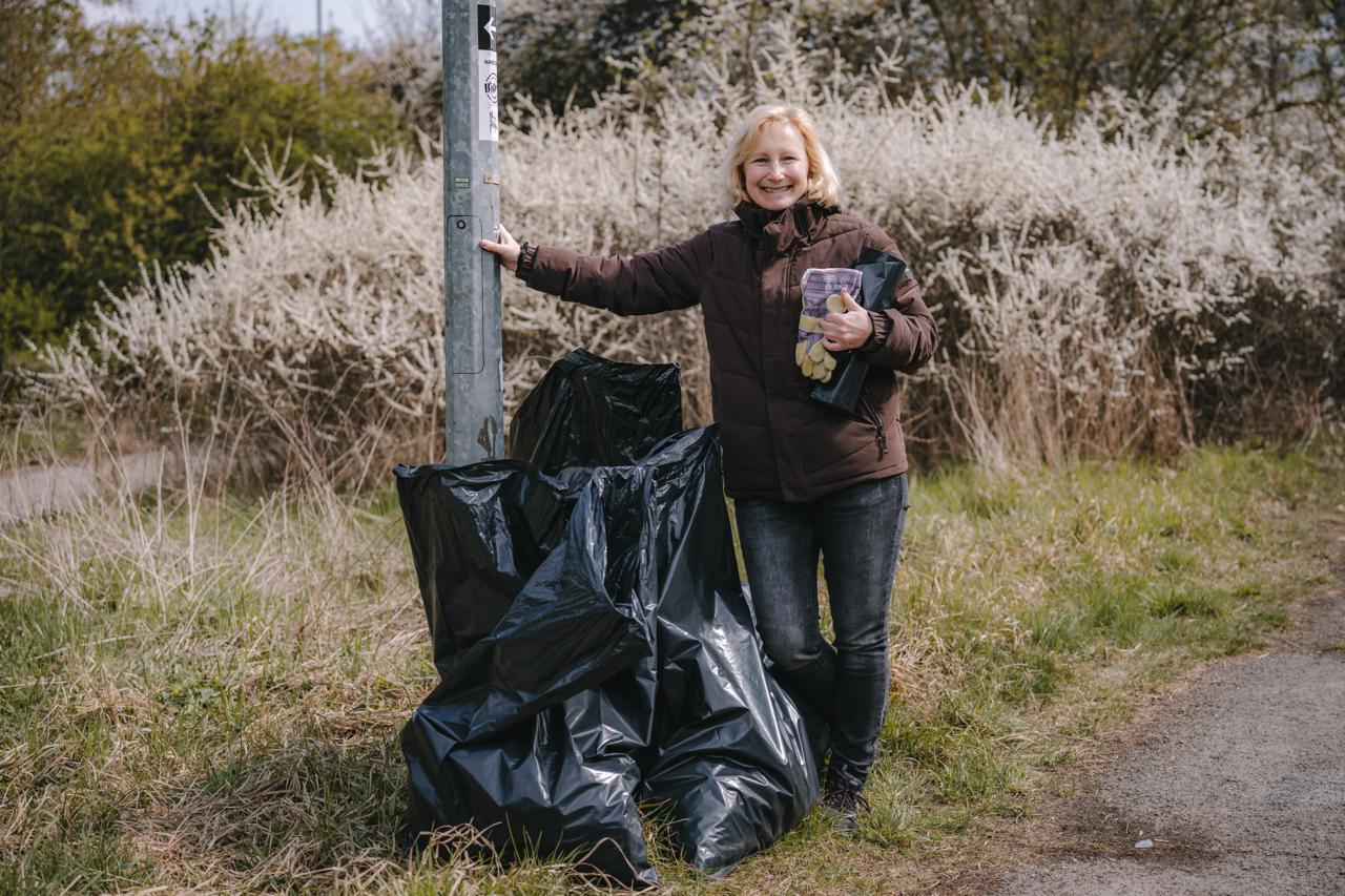 Dobrovolníci uklízí areál Džbán Praha 6 během komunitní akce
